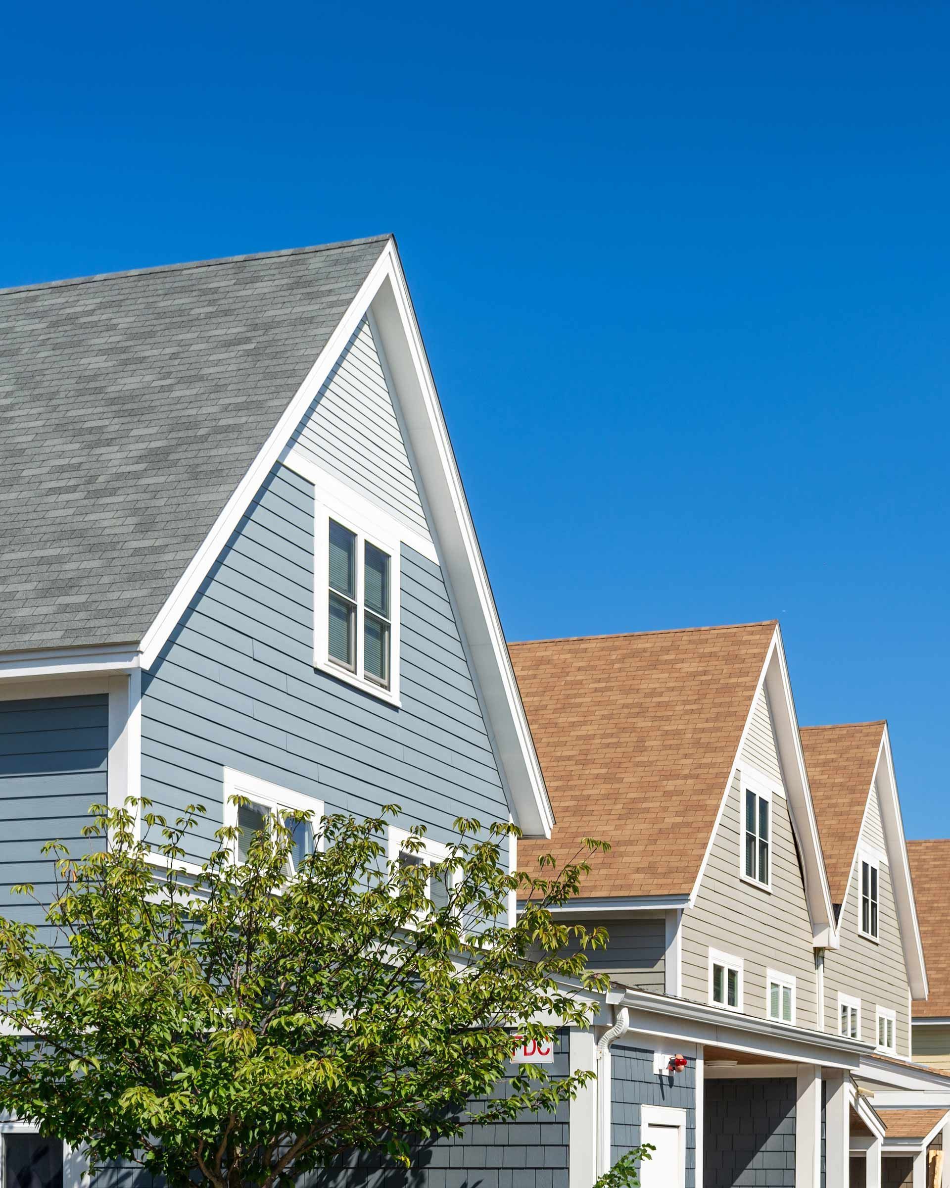 A row of houses with a blue sky in the background.