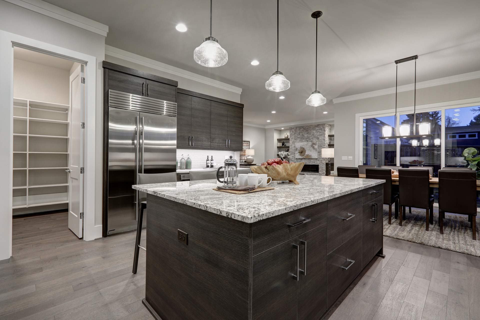 A kitchen with a large island in the middle and stainless steel appliances.