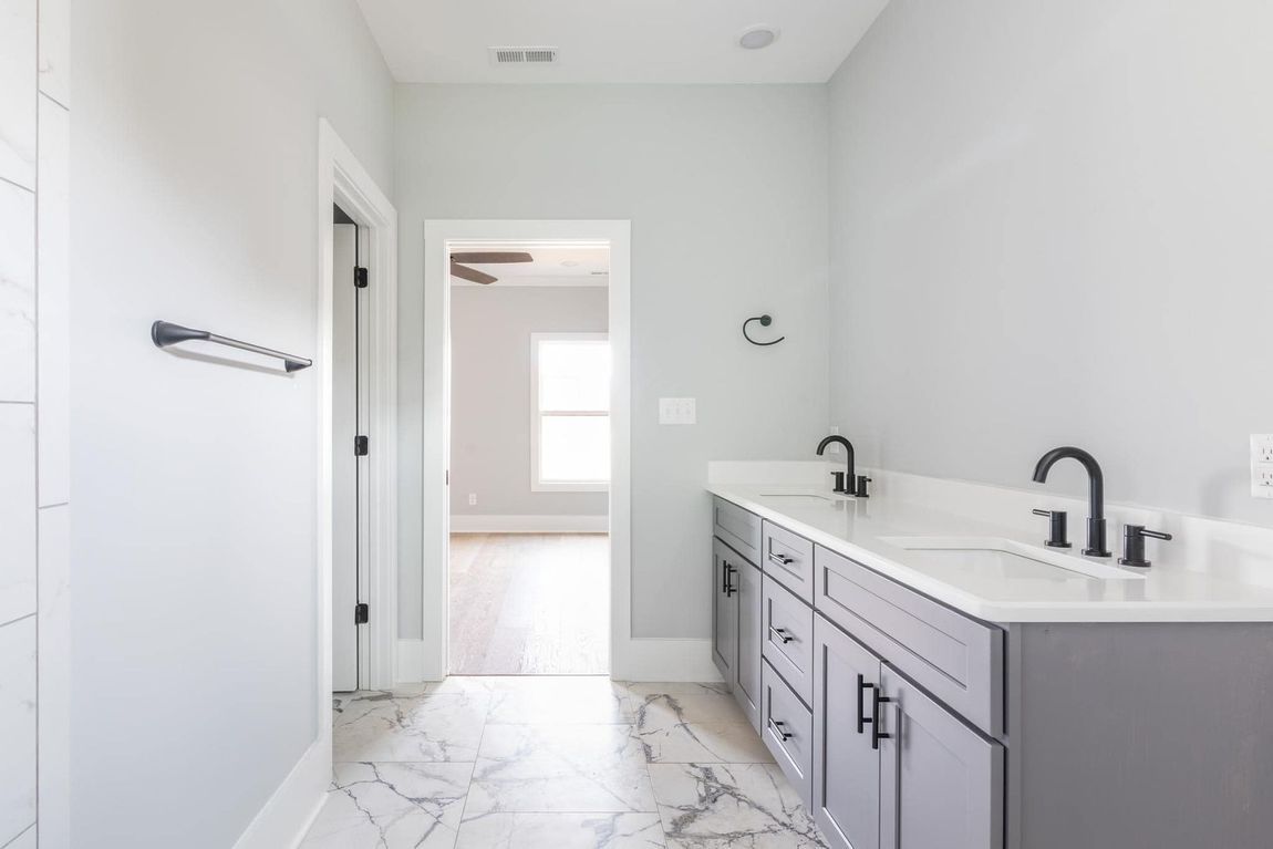 A bathroom with two sinks and a marble floor.