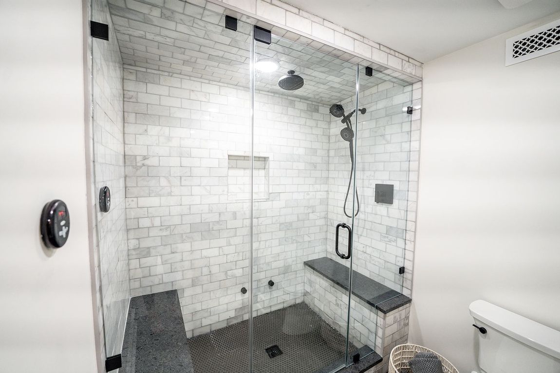A bathroom with a walk in shower and a toilet.