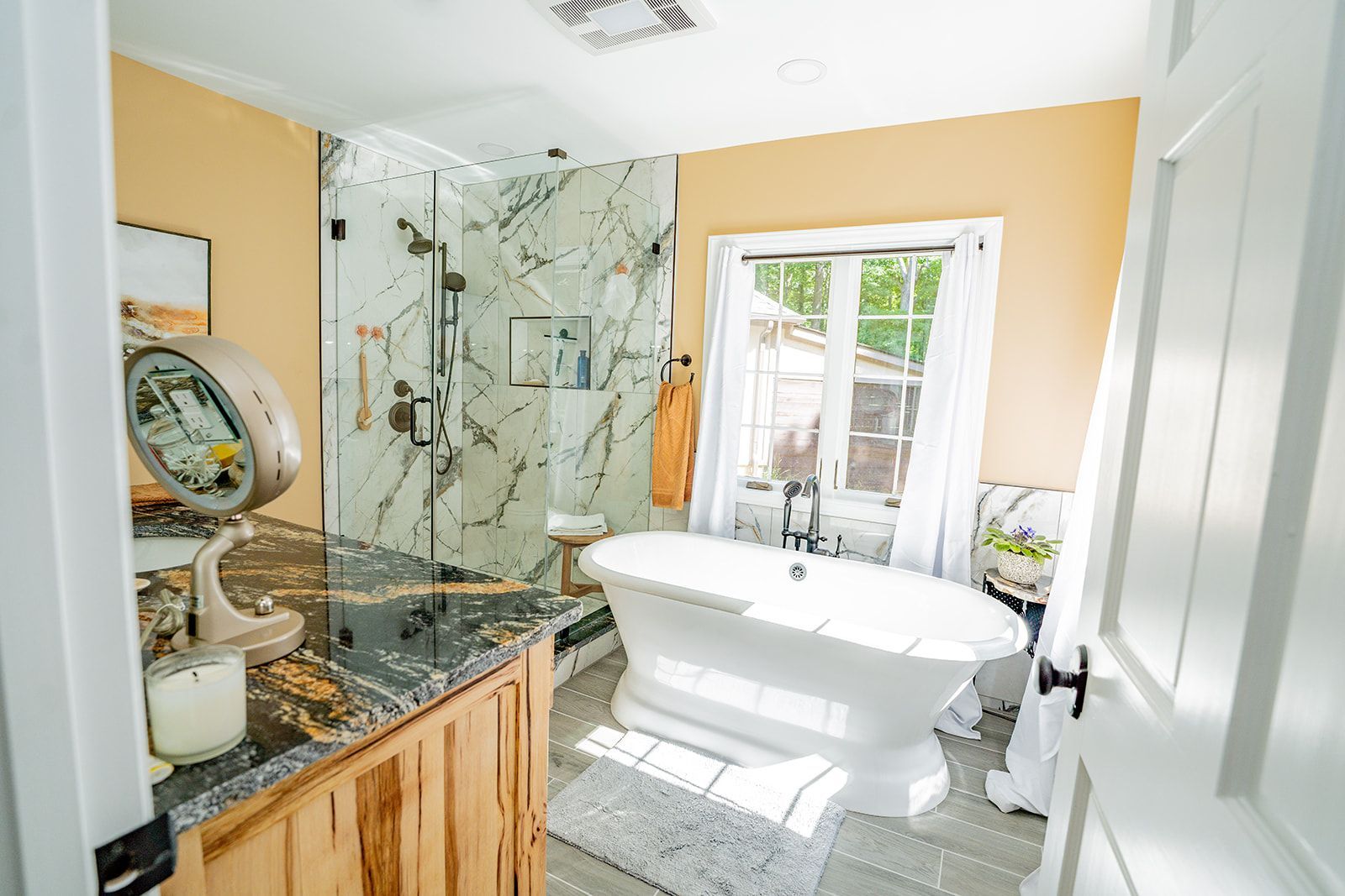 A bathroom with a tub , shower , sink and mirror.