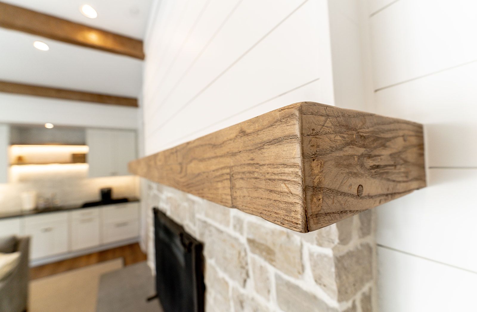 A fireplace with a wooden mantle in a living room.