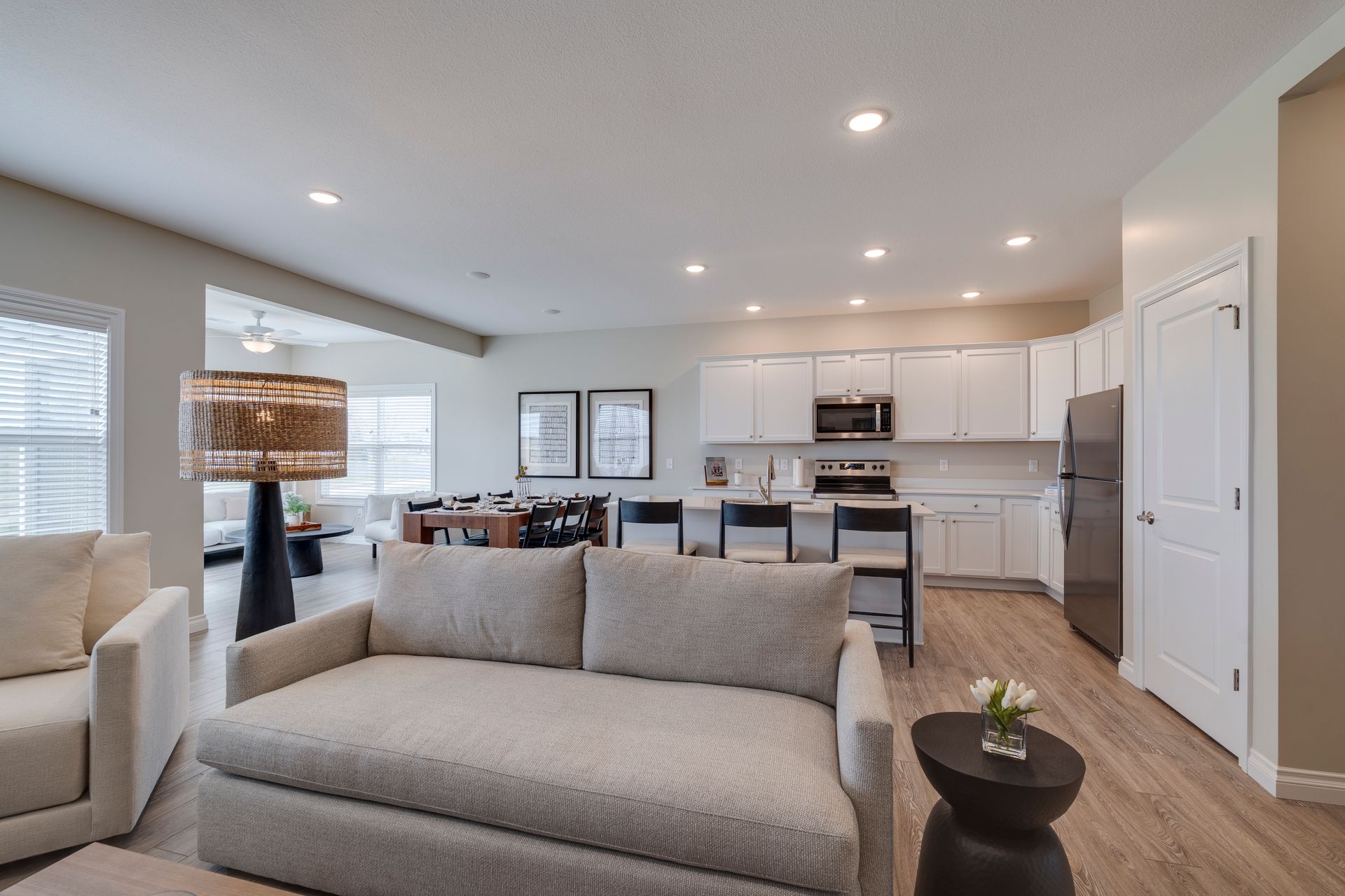 Photo of a wide, cozy couch with the dining room and kitchen in the background