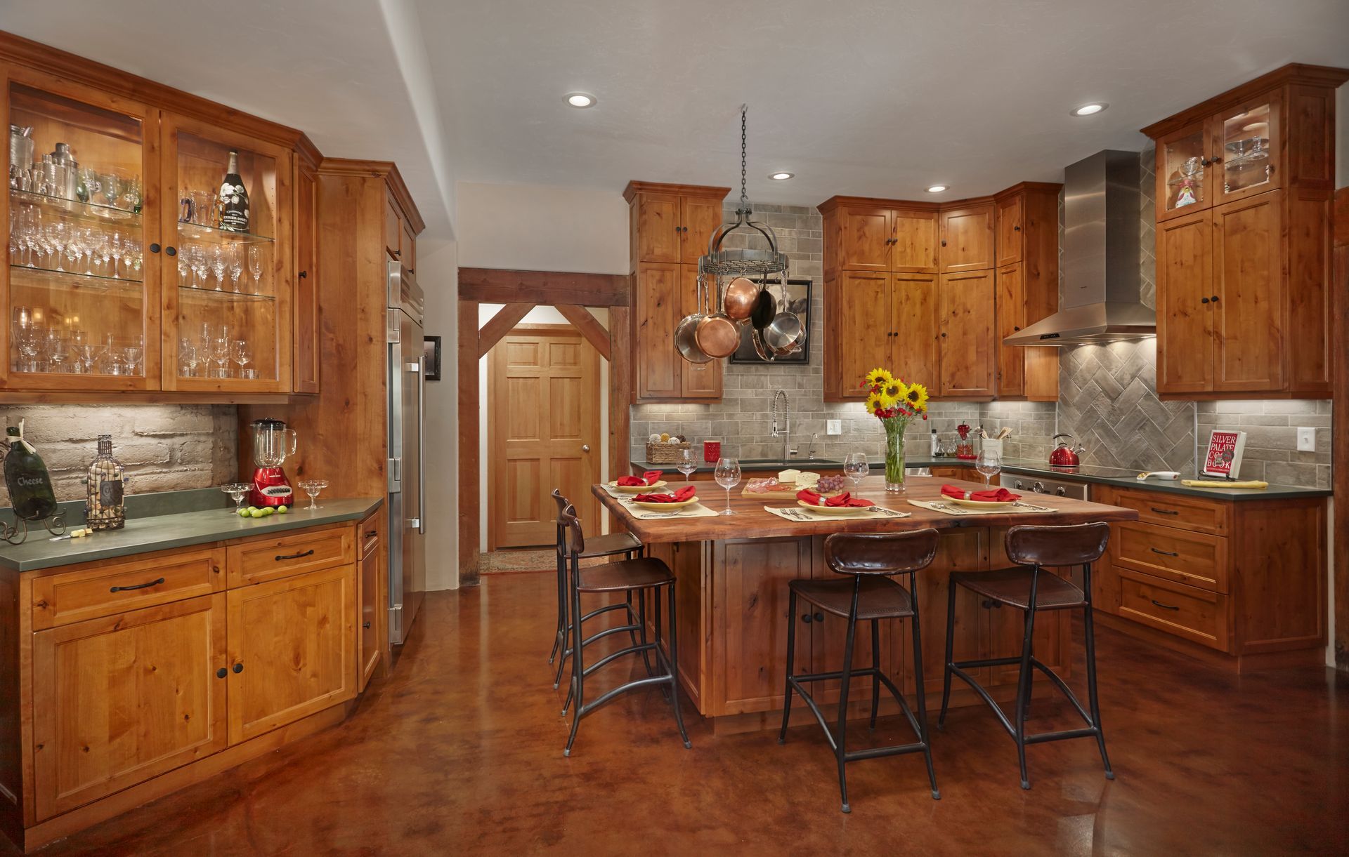 Rustic kitchen with wooden cabinets, island, and stone backsplash.