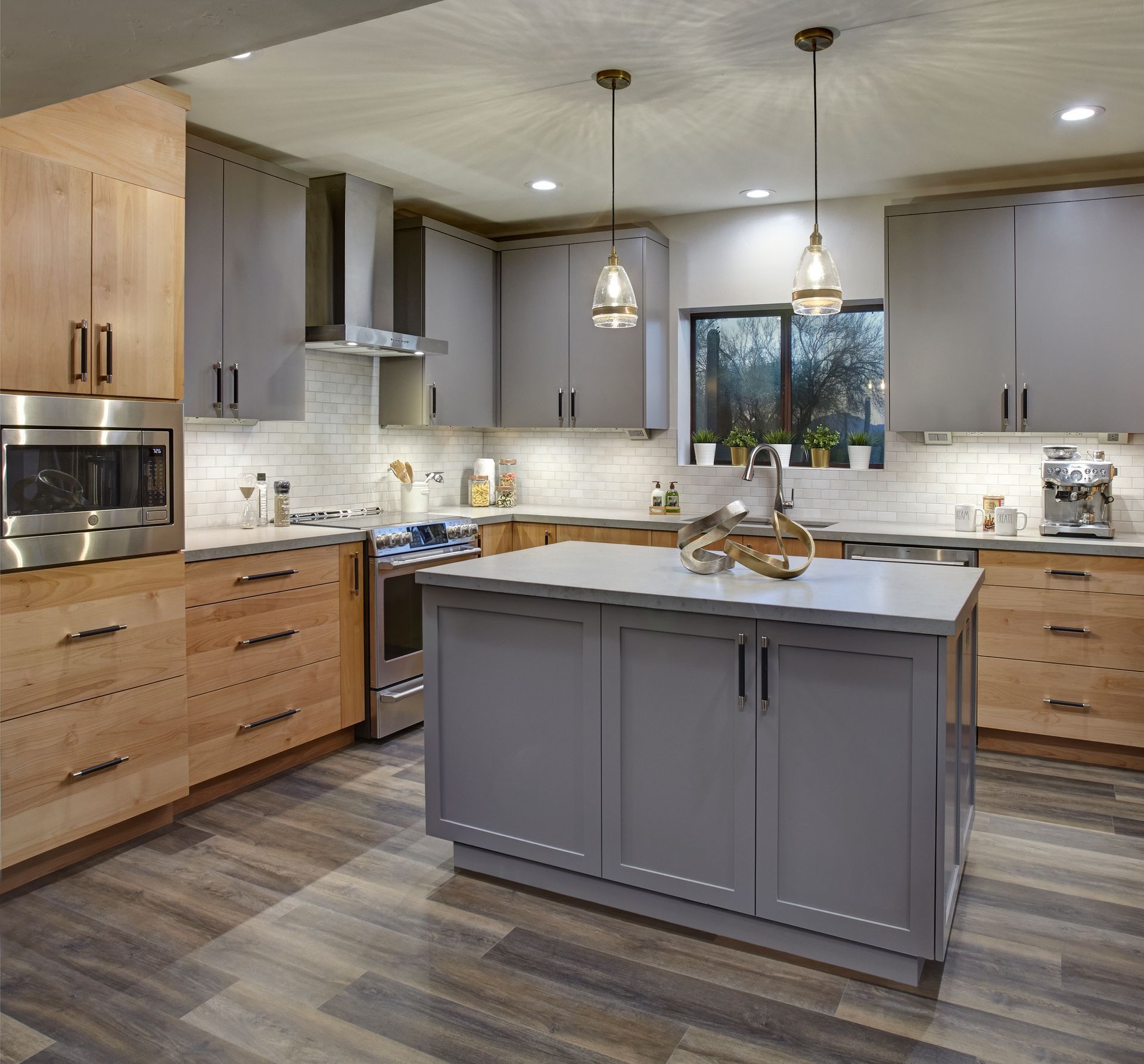 Modern kitchen with gray and wood cabinets, island, and pendant lights.