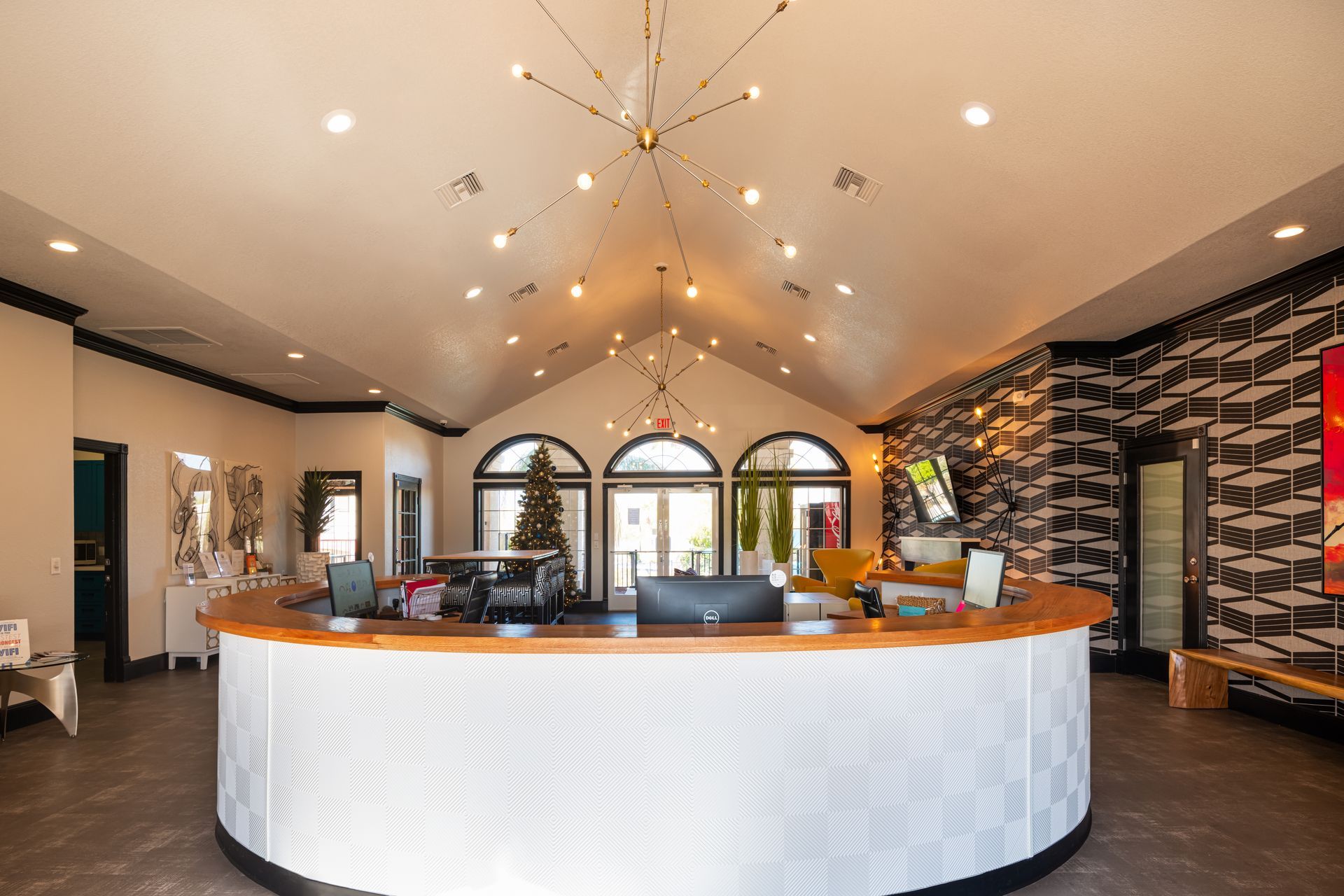 Reception area with curved white desk, black accents, and modern light fixture.
