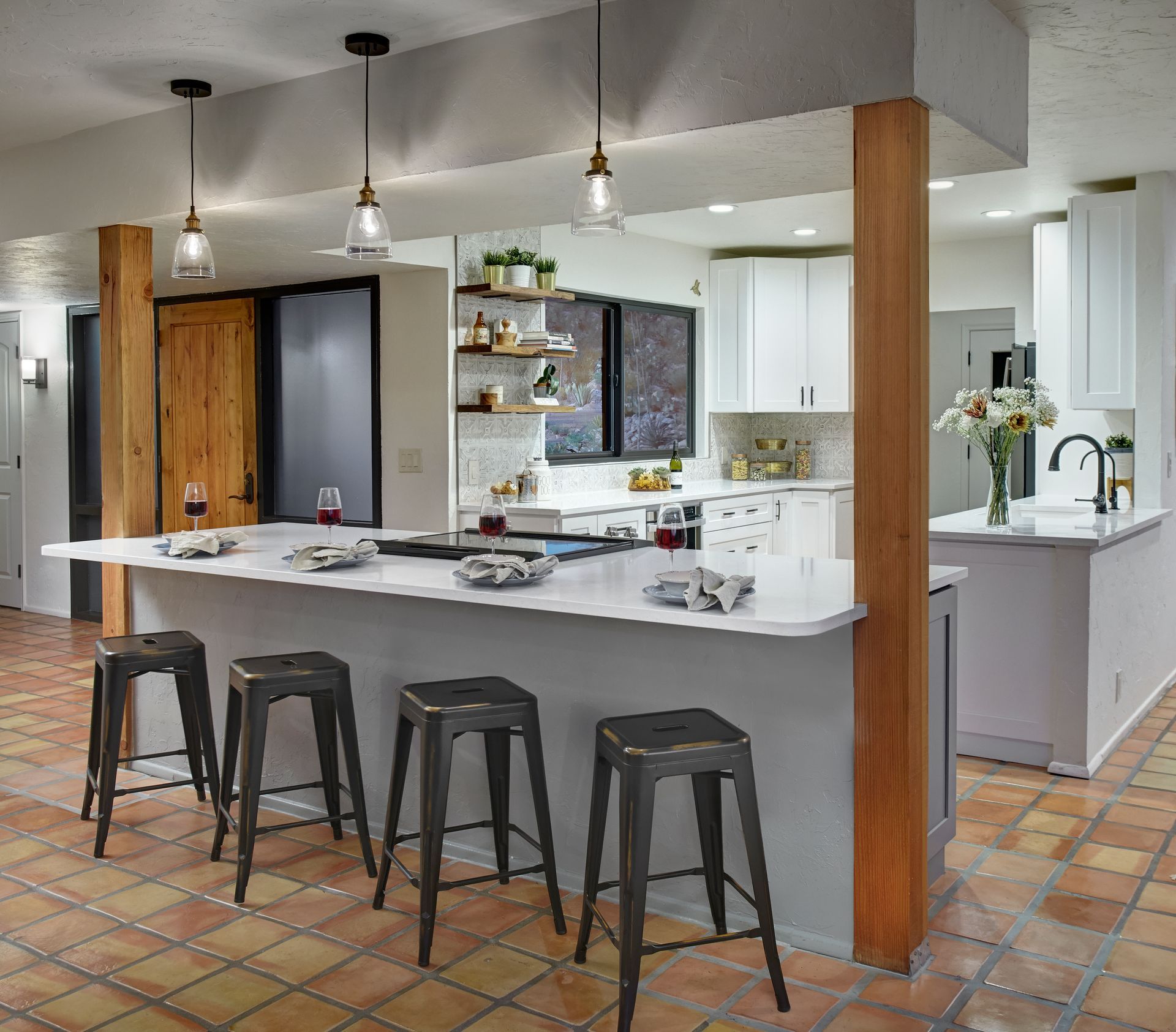 Modern kitchen with island seating and pendant lights; neutral tones and wood accents.