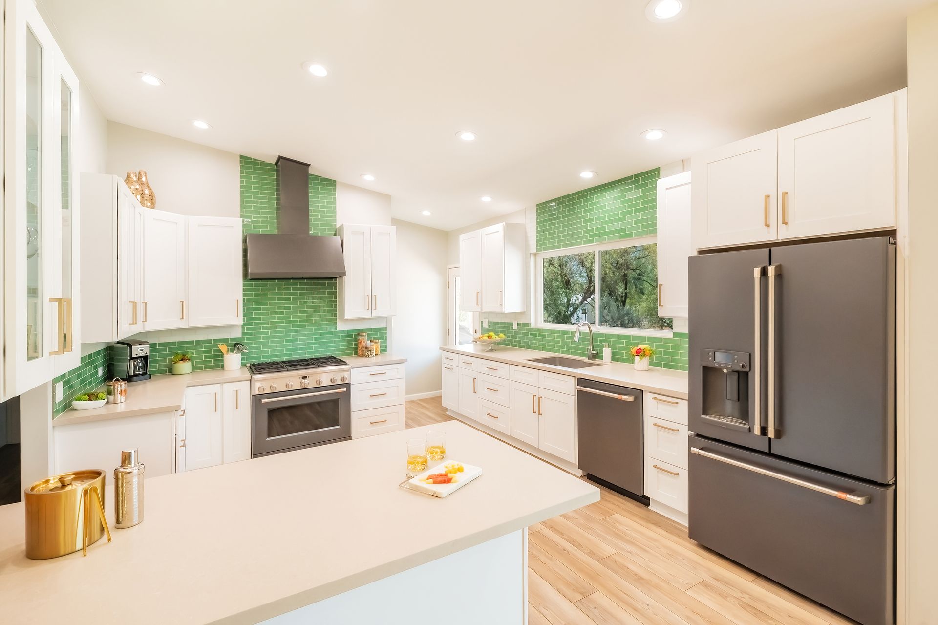 Modern kitchen with white cabinets, green backsplash, and black appliances.