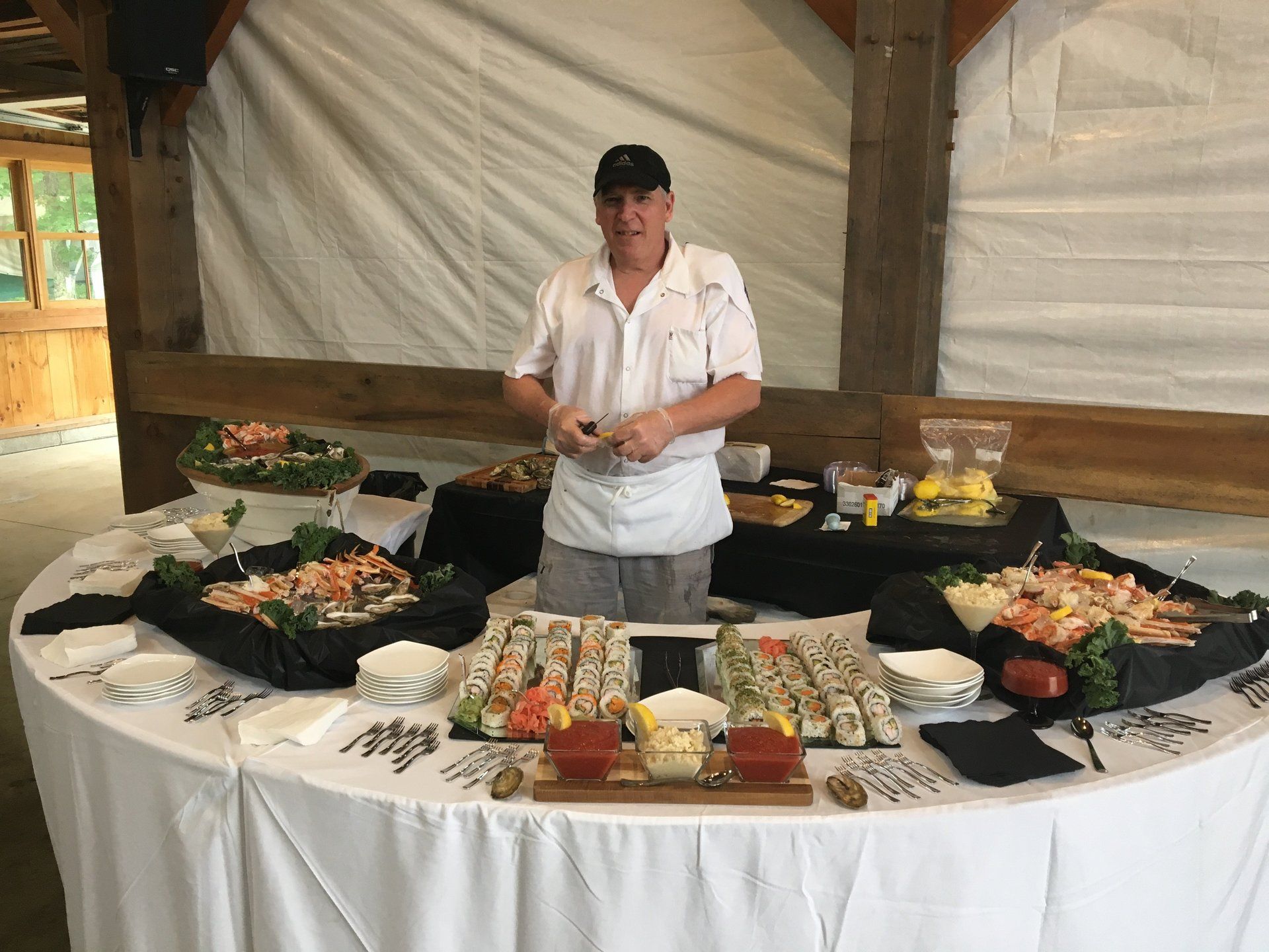 A man is standing in front of a buffet table filled with food