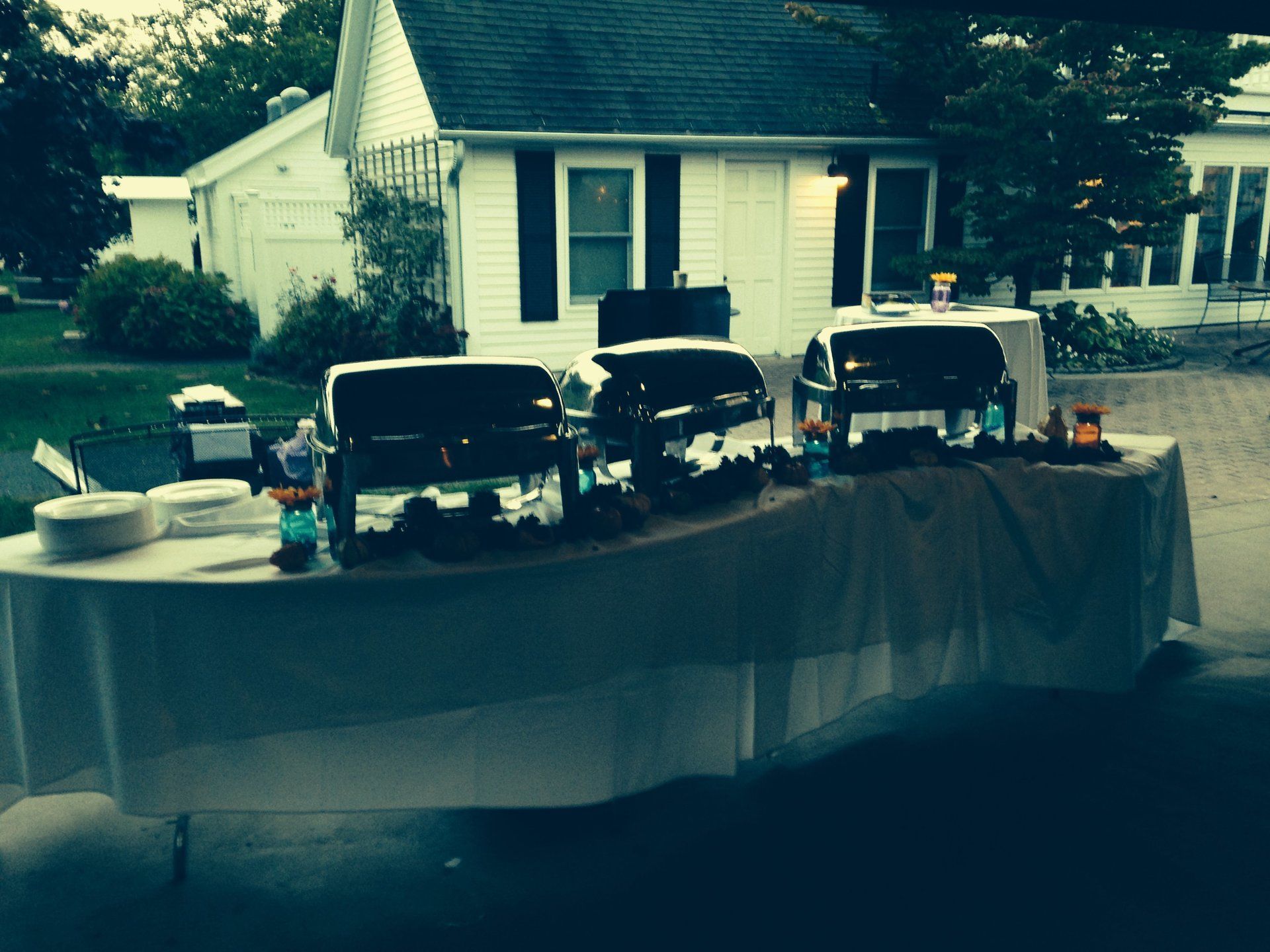 A buffet table is set up in front of a white house