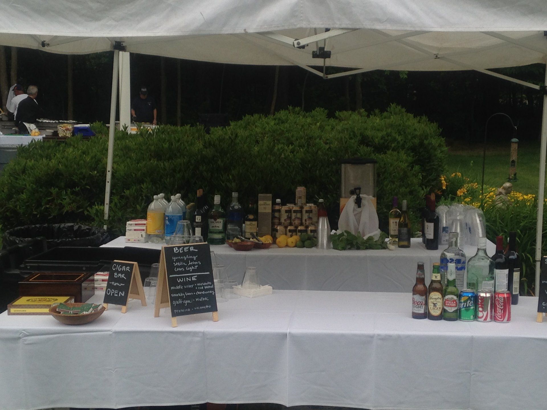 A table under a tent with bottles and a menu