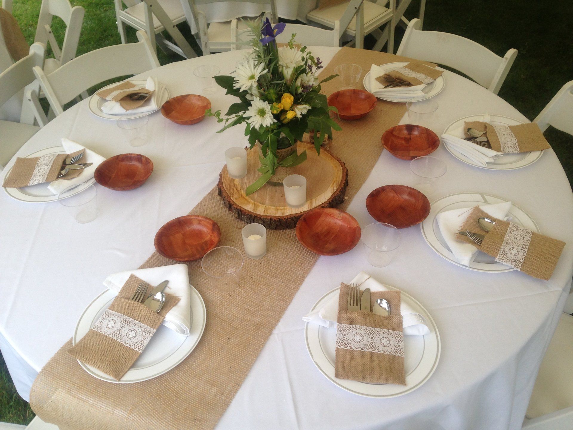 A table with plates bowls and a vase of flowers on it