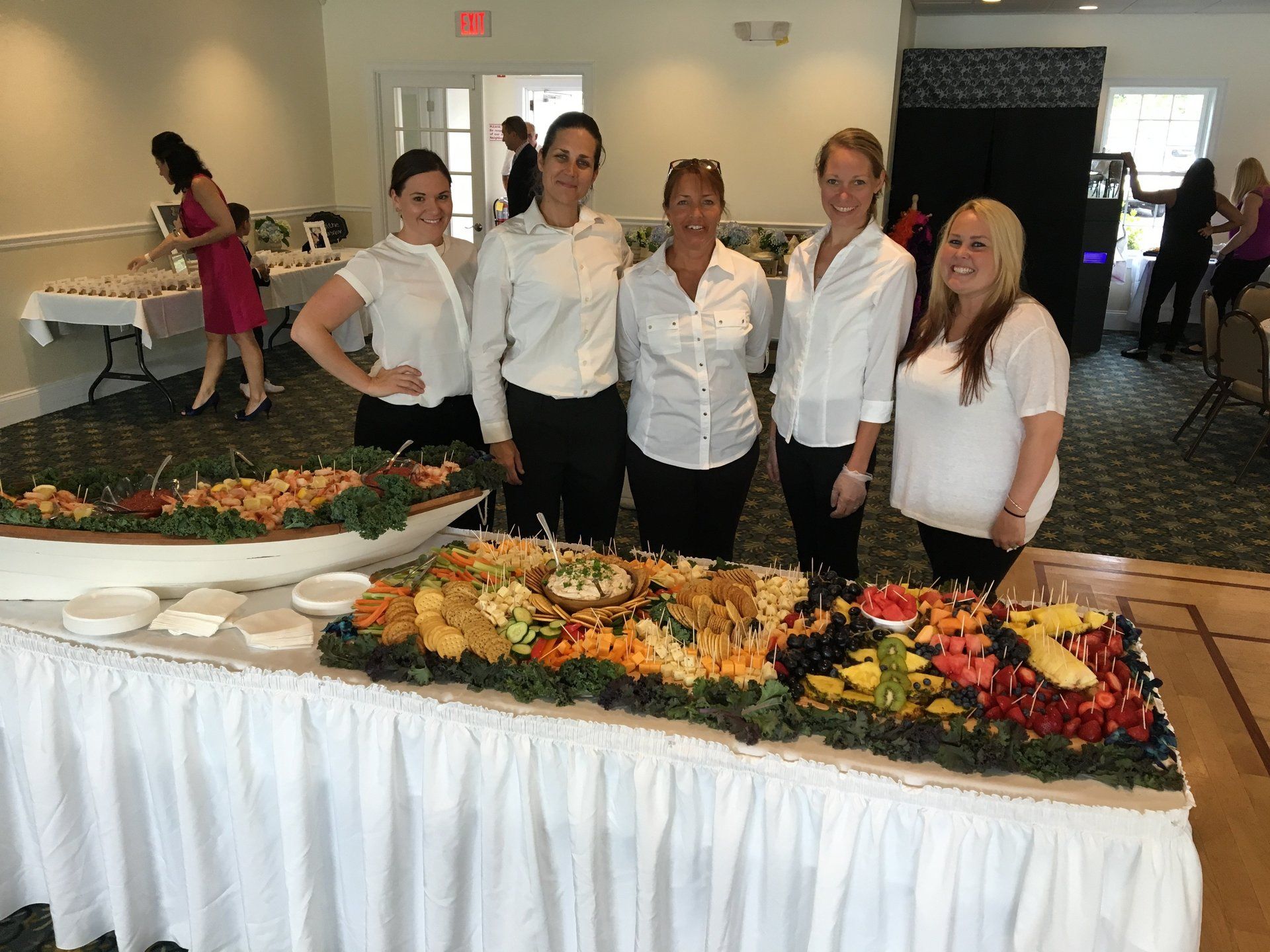 A group of women are standing in front of a buffet table