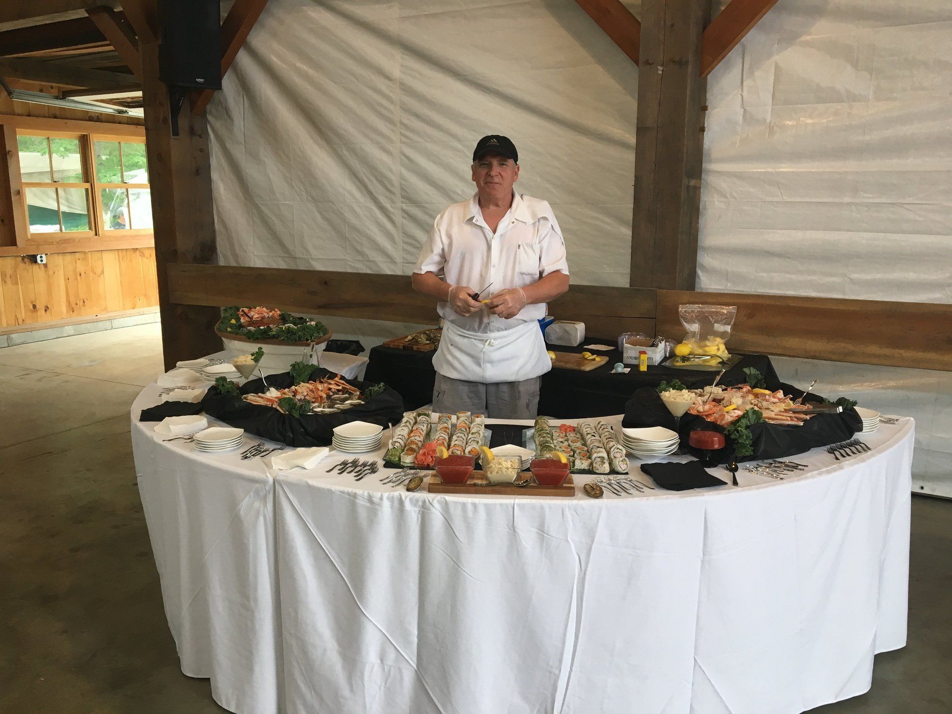 A man is standing in front of a buffet table with food on it