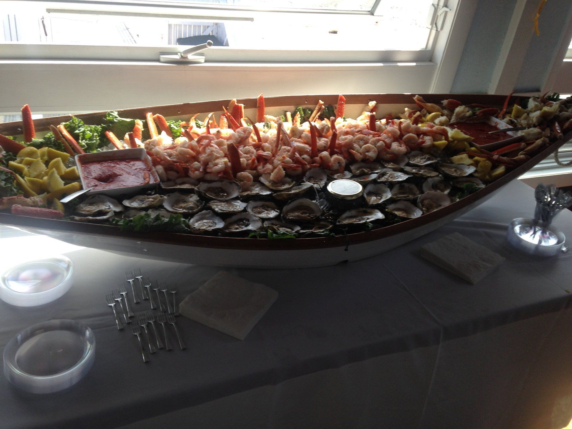 A boat filled with food is sitting on a table in front of a window