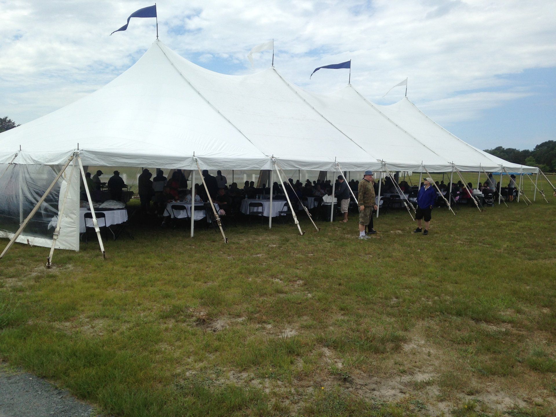 A large white tent with people sitting underneath it