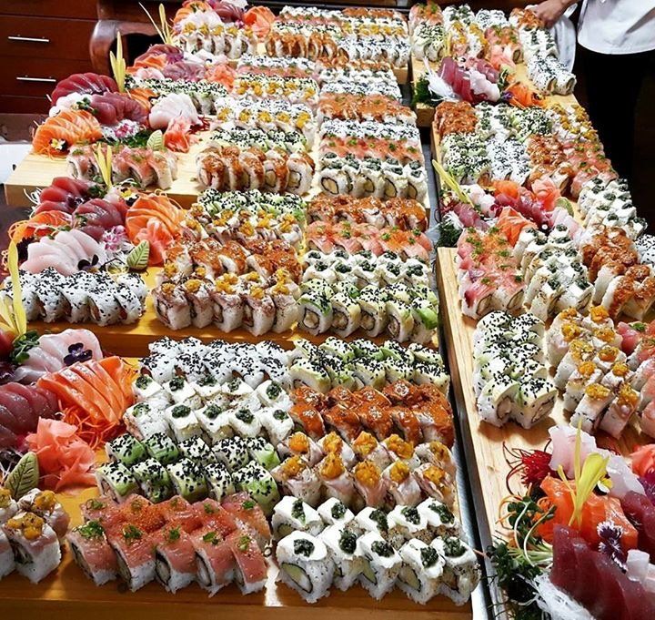 A large display of sushi and sashimi on a wooden table