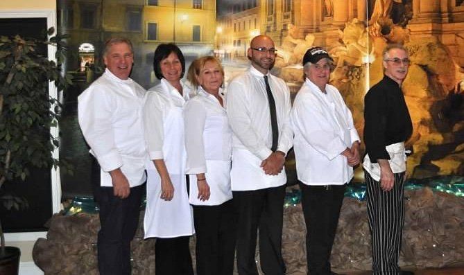 A group of people in white coats are posing for a picture