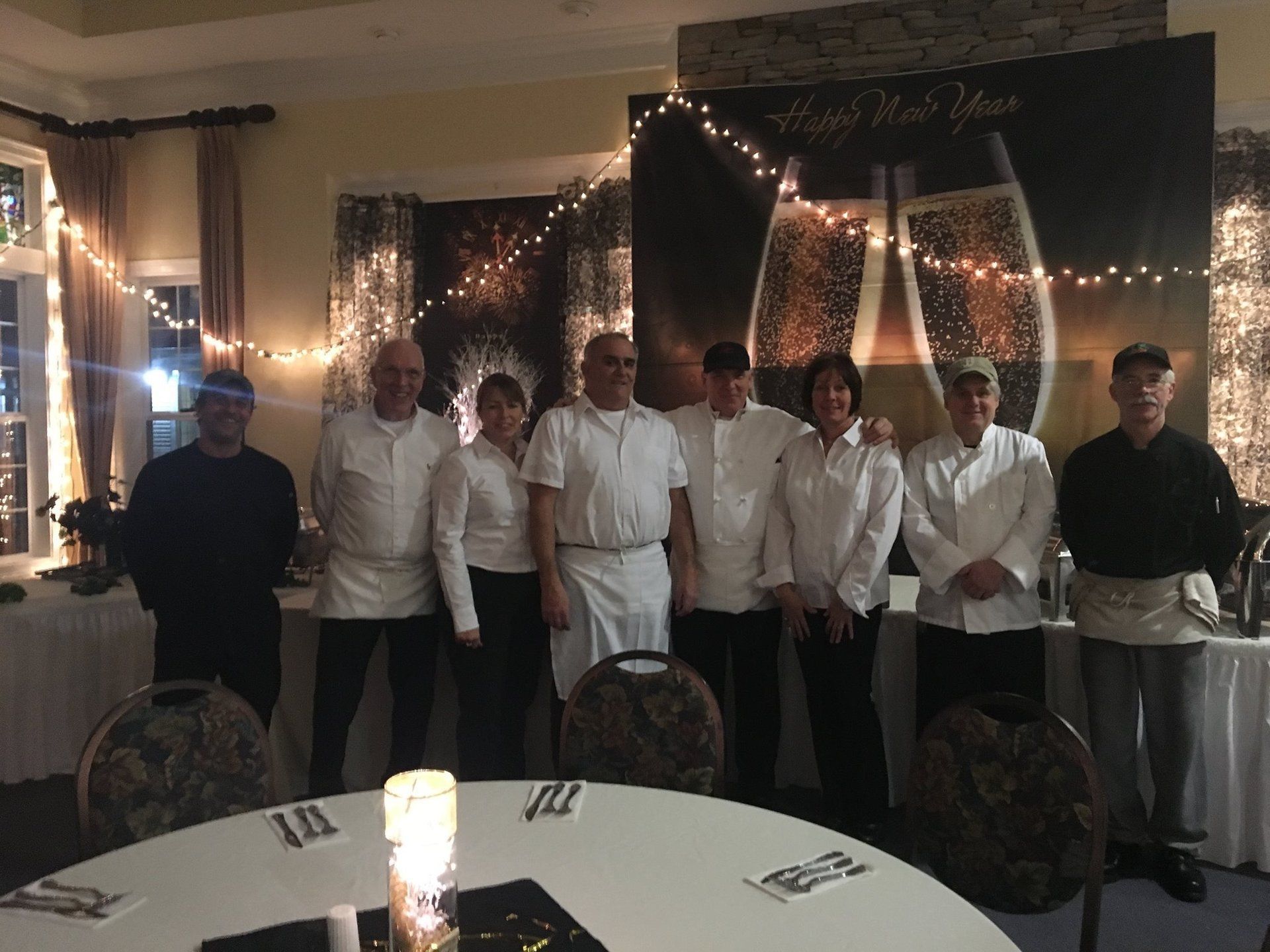 A group of people are posing for a picture in front of a table