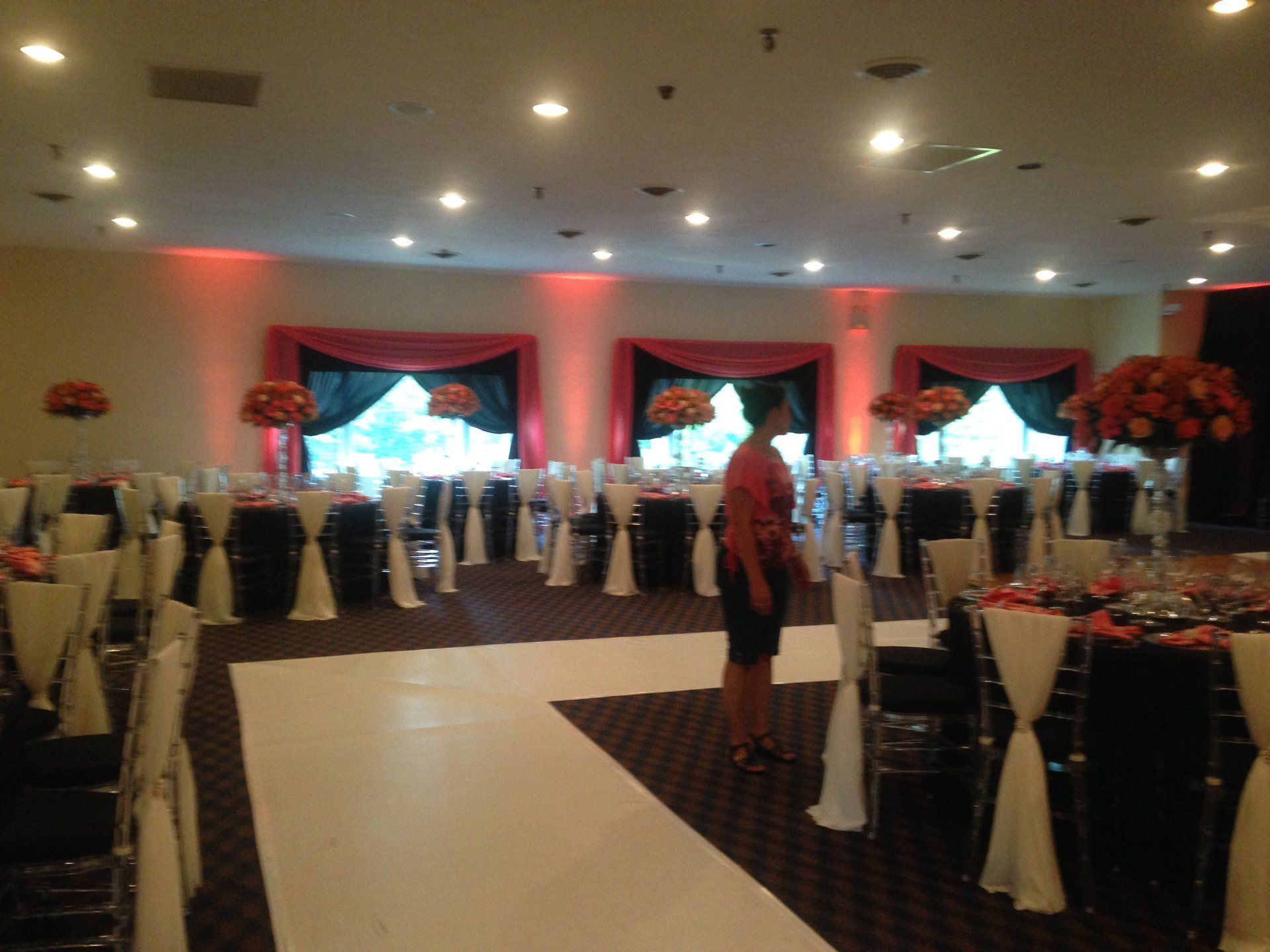 A woman stands in a large room with tables and chairs