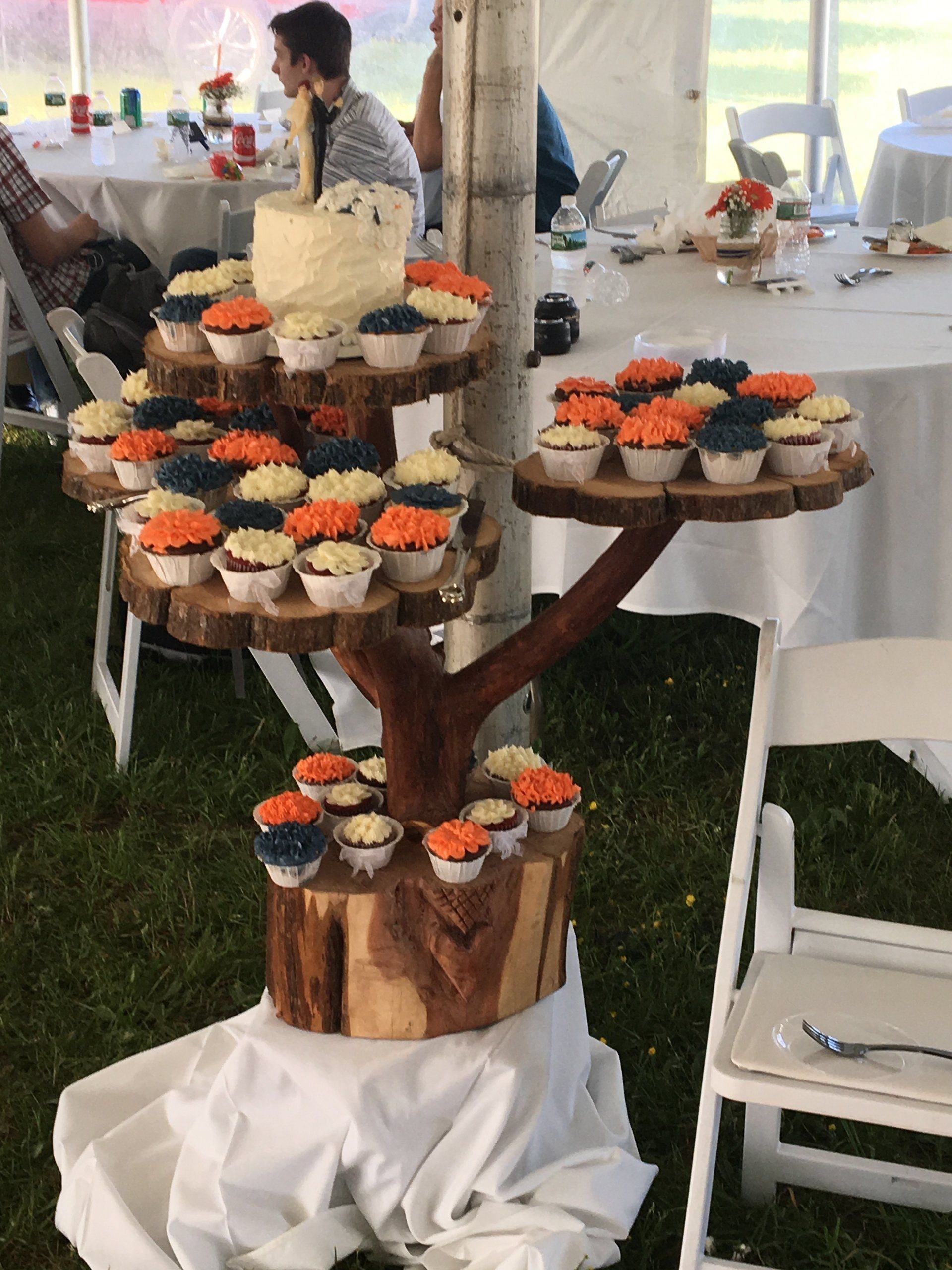 A wooden tree-shaped cupcake stand with cupcakes on it