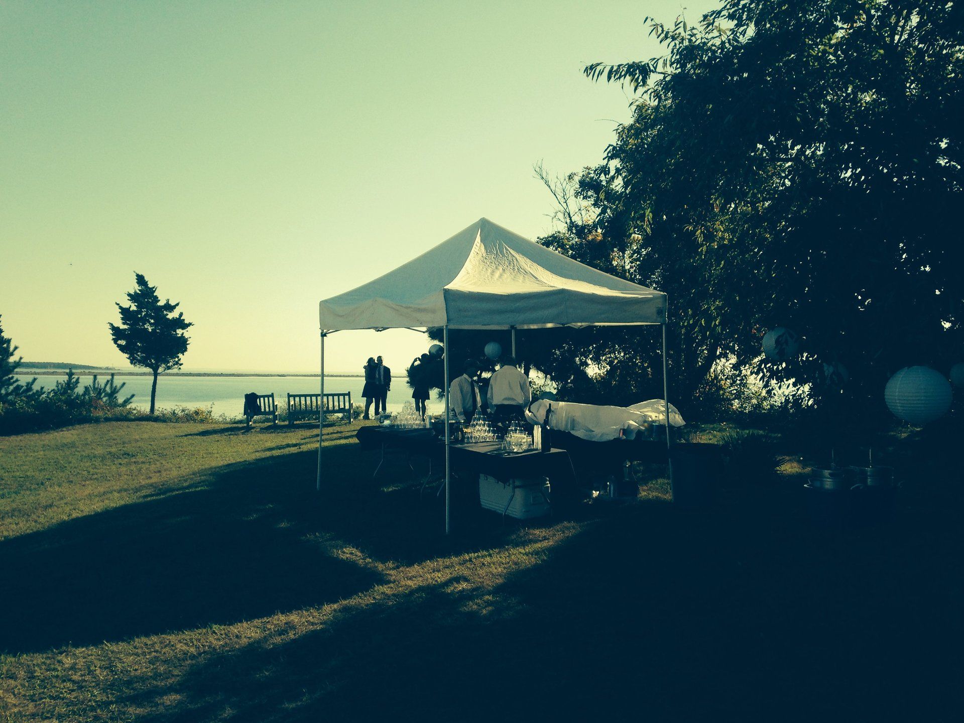 A white tent on top of a grassy hill