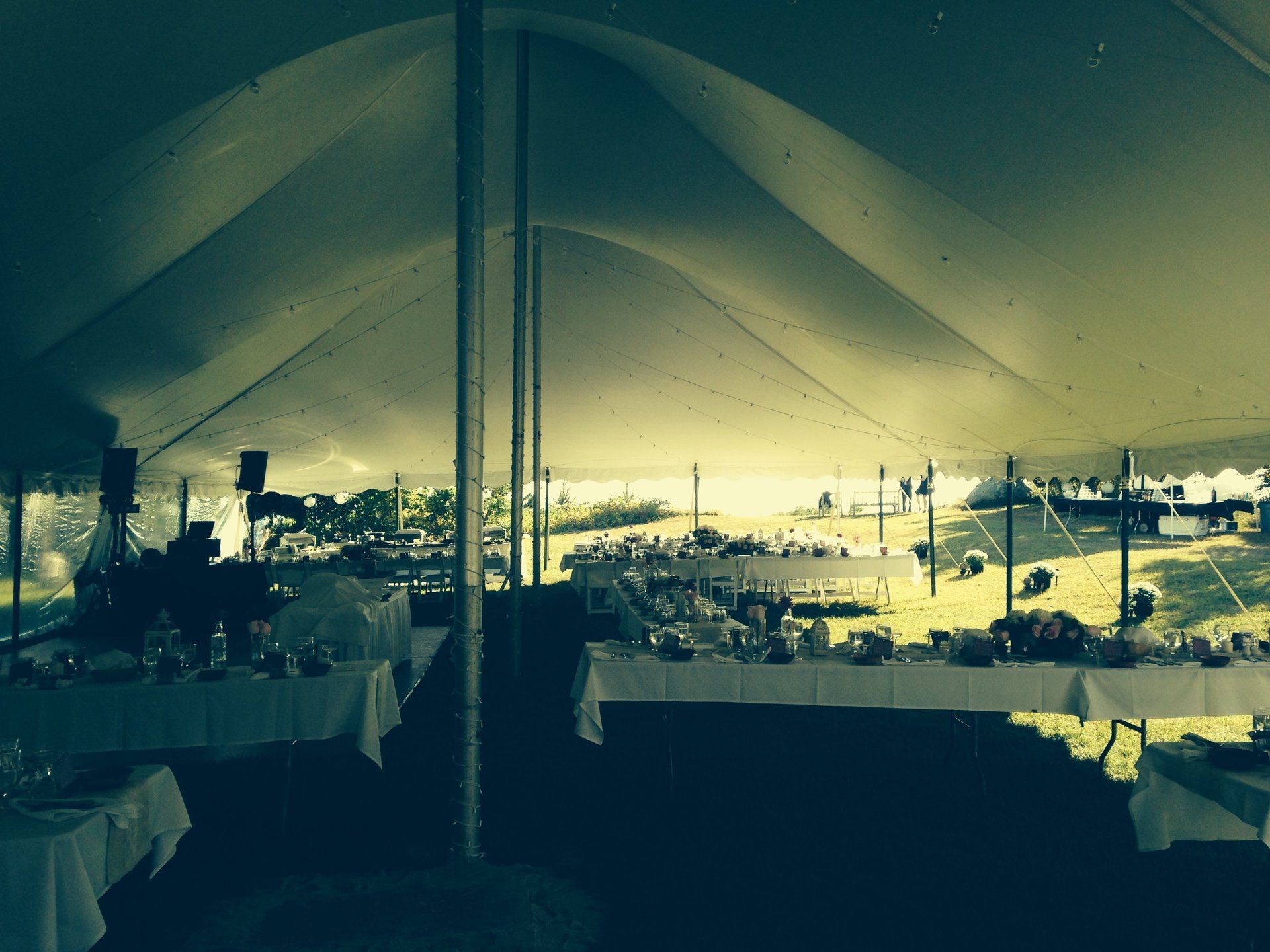 A large tent with tables and utensils inside of it