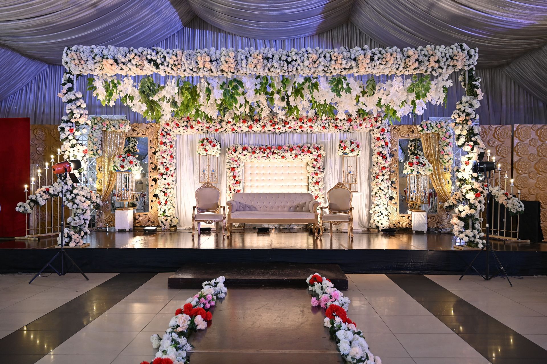 A stage decorated with flowers and candles for a wedding reception