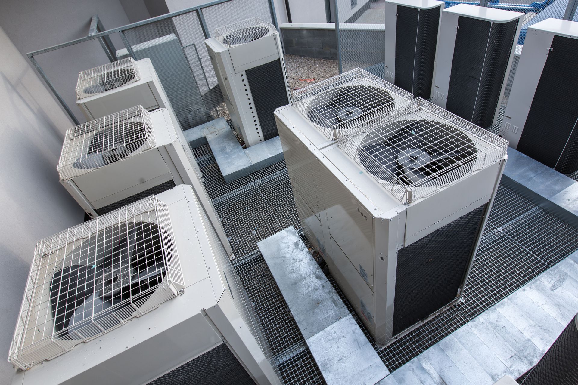 Rooftop HVAC units with large cooling fans arranged on a metal platform