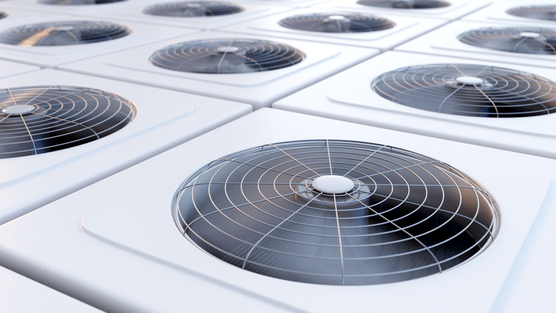 Row of white rooftop air conditioning units with circular metal fans