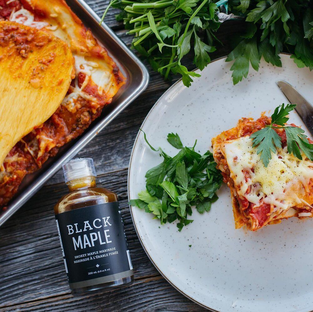 A bottle of black maple next to a plate of food