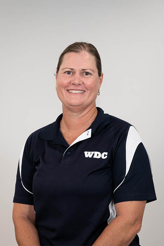 Woman in navy WDC polo shirt smiling against a light gray background
