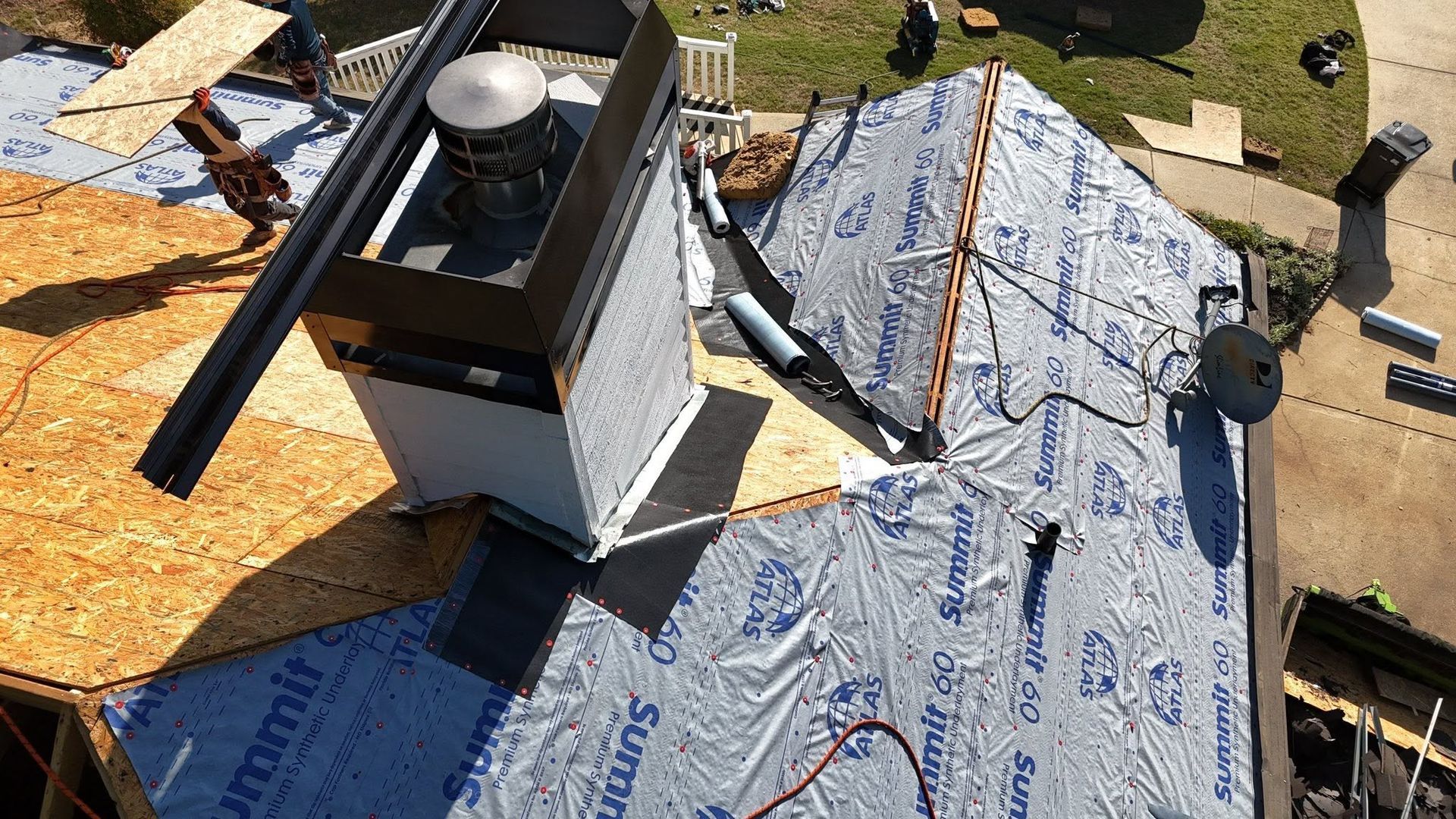 Roof under repair with roofing materials, underlayment, and a vent chimney visible on a sloped roof