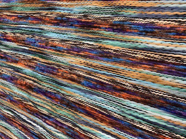 Un primo piano di una coperta con un arcobaleno di colori.