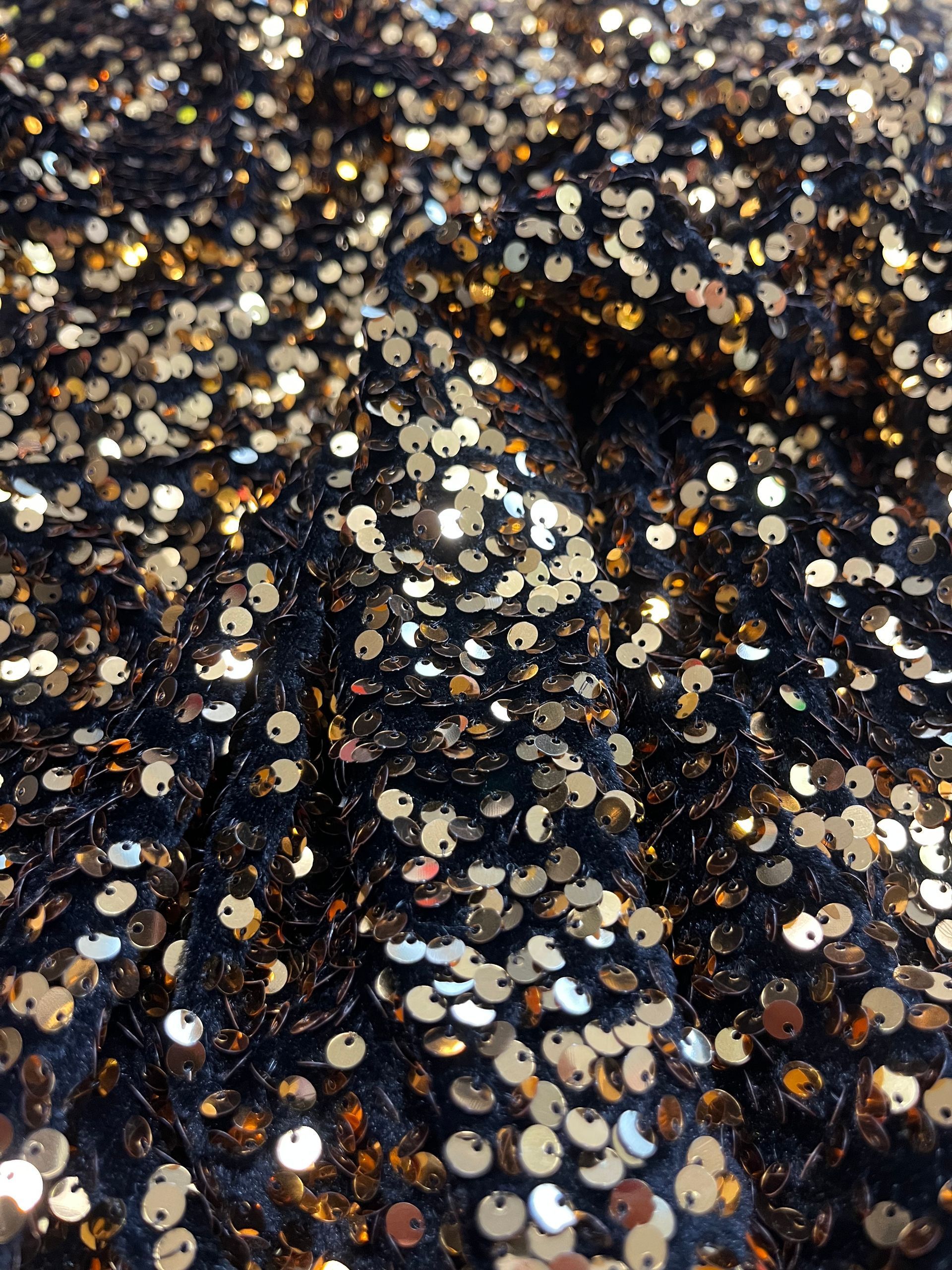 Un primo piano di un tessuto con paillettes nere e dorate