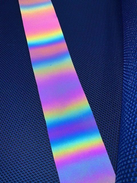 Primo piano di un nastro color arcobaleno su una superficie blu.
