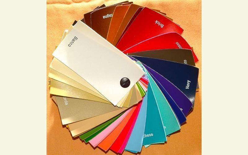 Un mucchio di fogli di carta di diversi colori disposti in cerchio, uno dei quali ha la parola 