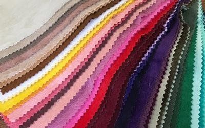 Un mucchio di tessuti di colori diversi sono impilati uno sopra l'altro.
