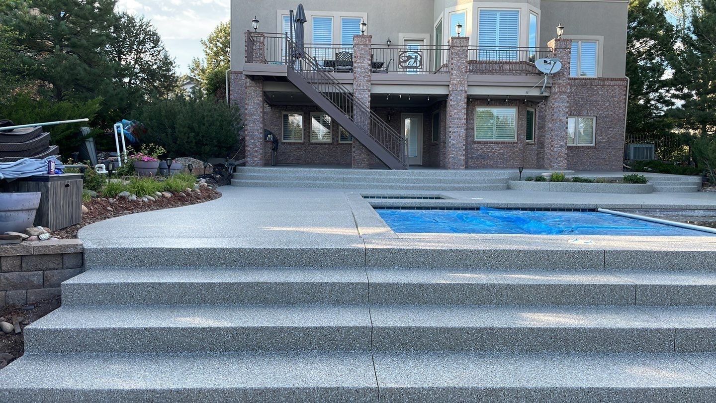Backyard patio with steps, pool, and multi-level brick deck with stairs and seating.
