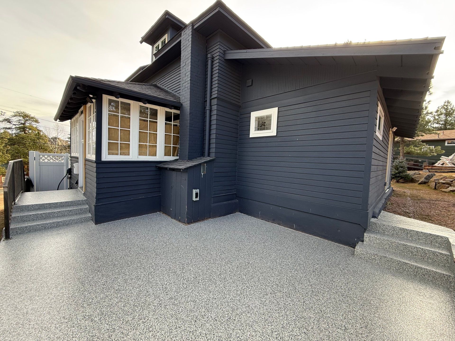 Dark blue modern house exterior with gravel driveway and bay window frontage