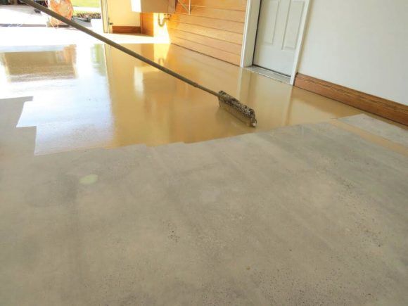 Long-handled cleaning tool on a shiny indoor floor near a doorway and baseboard