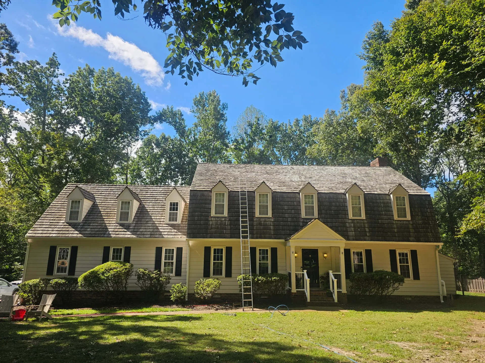 A residential home featuring a newly installed composite shingle roof with multiple dormers and a covered front entrance by D & B Services