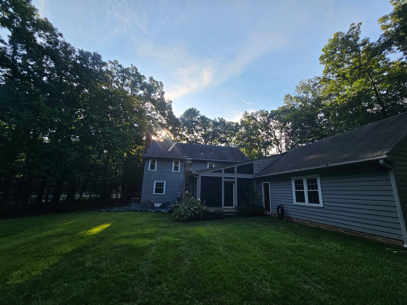 A residential home featuring a recently installed or maintained roof with dark asphalt shingles across multiple roof sections