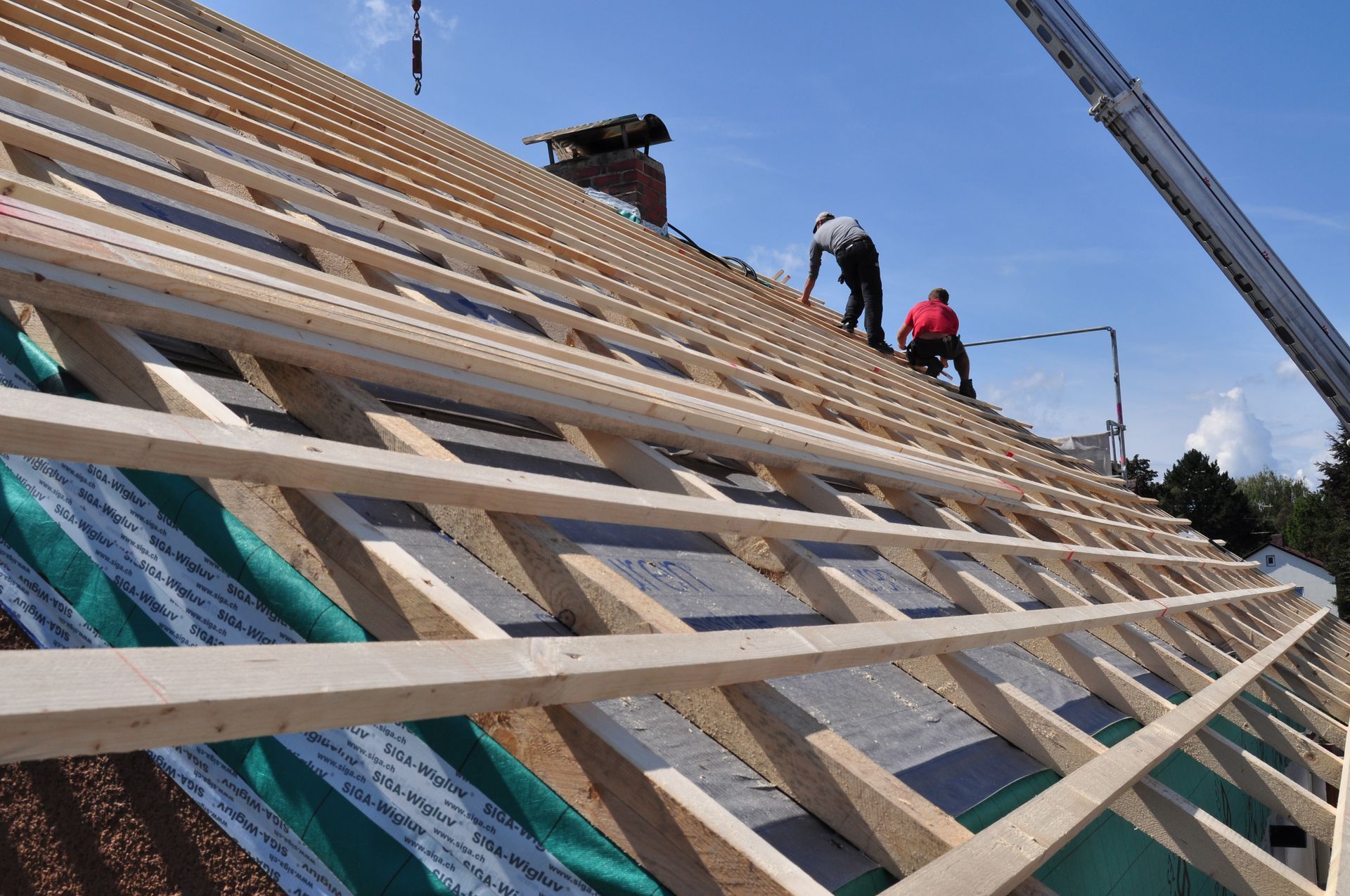 A two-story brick residential home featuring a recently installed roof with multiple gable sections and asphalt shingles by D