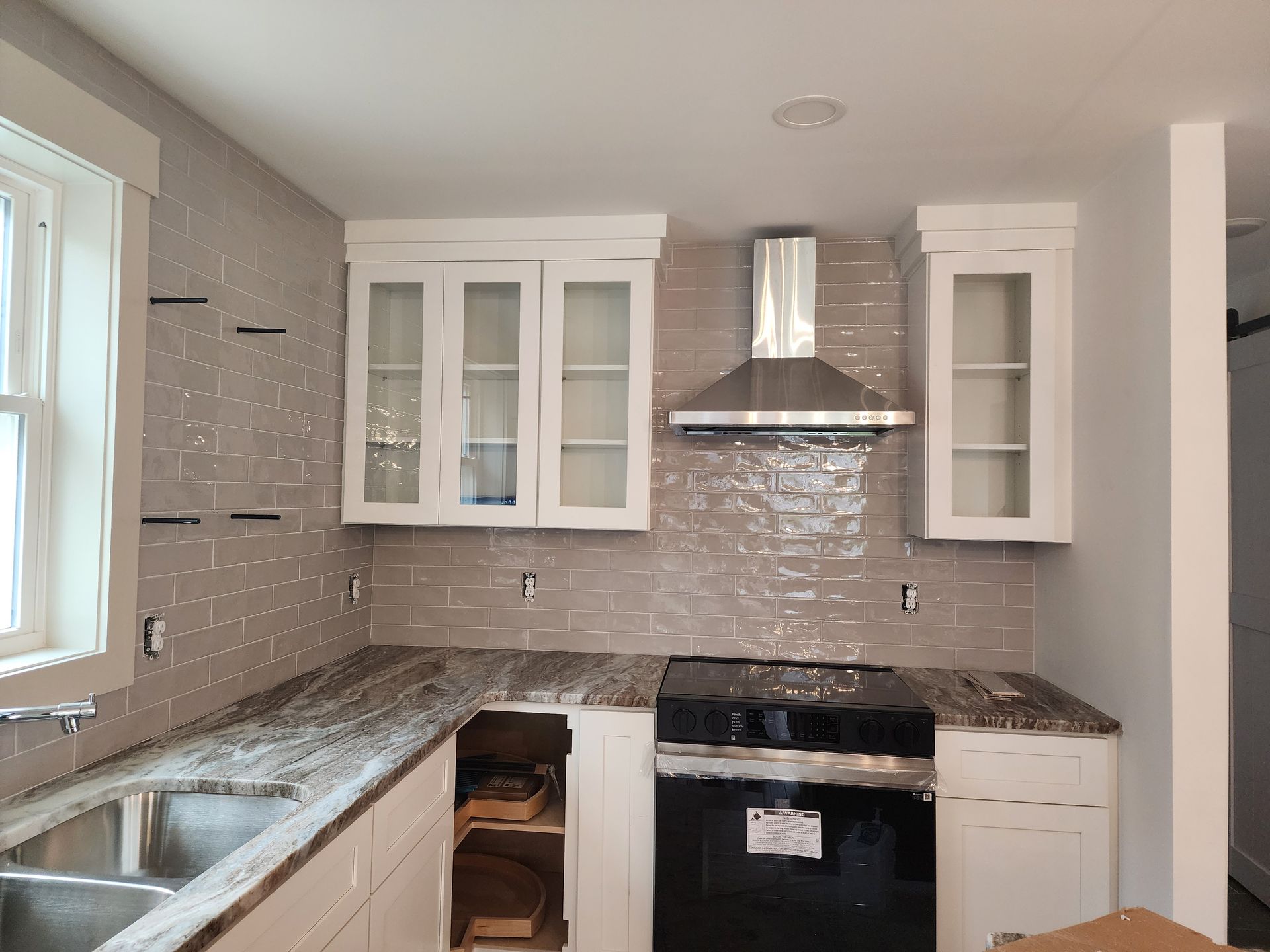 A kitchen with white cabinets and a black stove