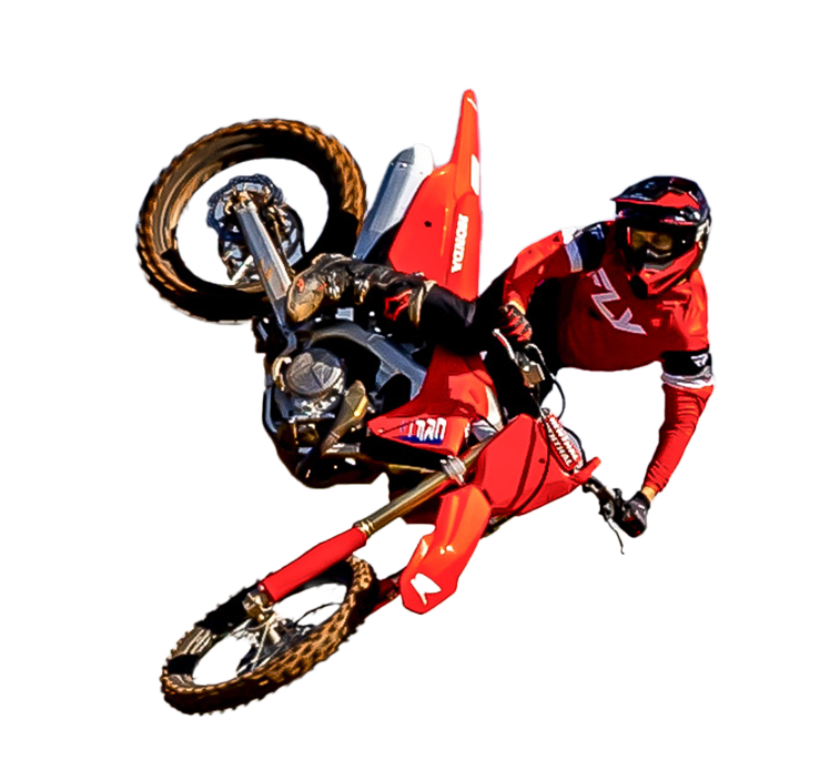 Motociclista com equipamento vermelho fazendo uma acrobacia, moto inclinada de cabeça para baixo.