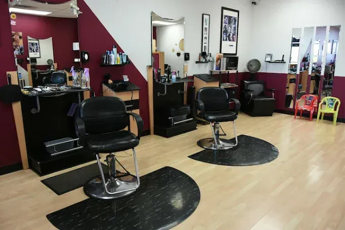 A hair salon with two chairs and a mirror