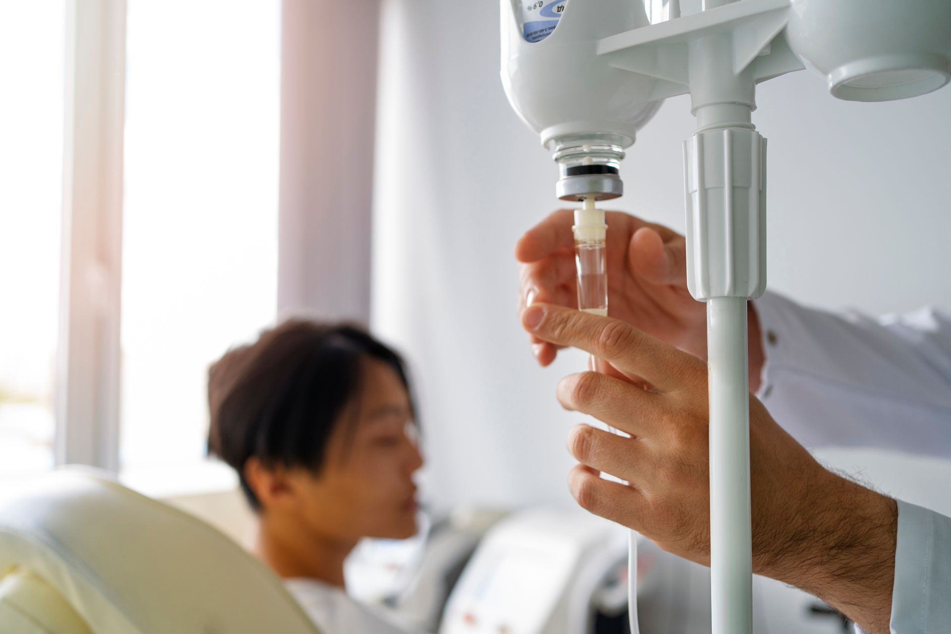 a doctor is giving an injection to a patient in a hospital bed .