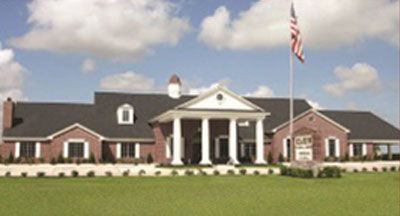 Red brick building with white columns and an American flag.