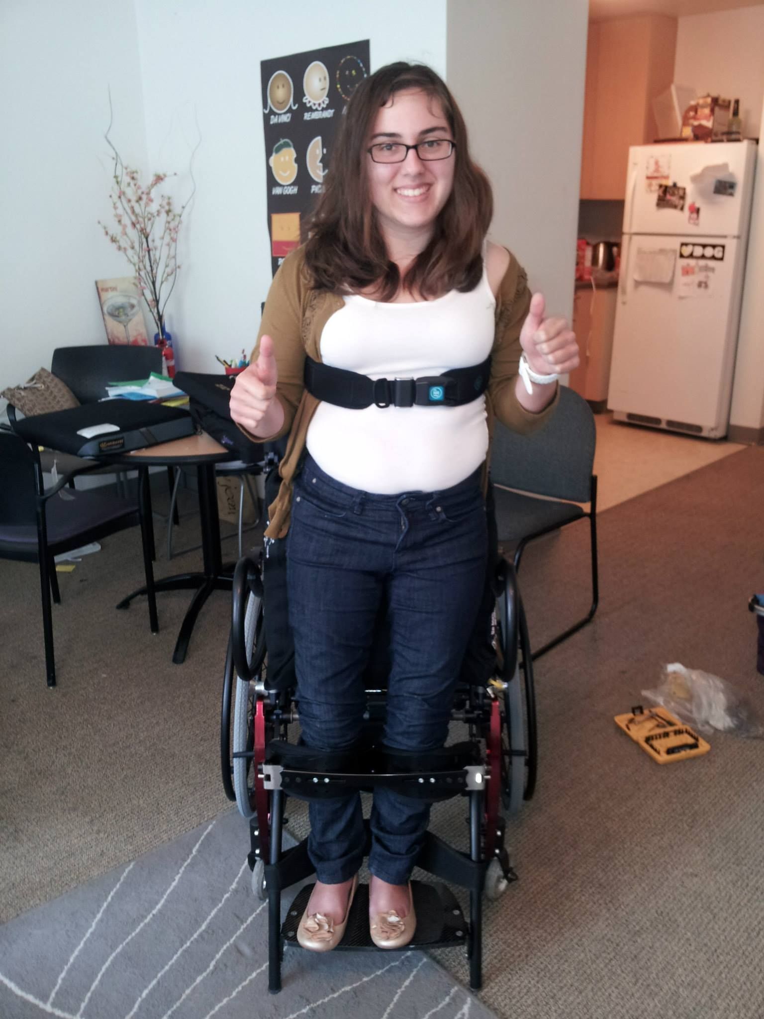 A woman in a wheelchair is giving a thumbs up
